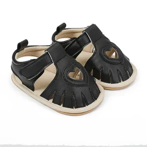 Detail of black infant summer sandals featuring a delicate heart-shaped cut-out design.