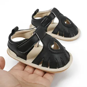 Detail of black baby sandals with heart cutout and velcro strap for infants