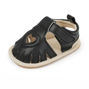 Close-up of black baby sandal featuring a heart-shaped cutout and breathable design.