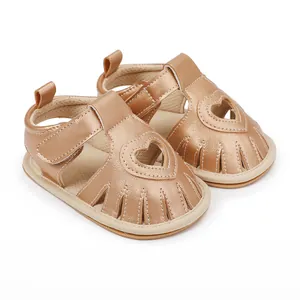 Detailed view of champagne gold baby sandals with heart-shaped cutout and Velcro strap
