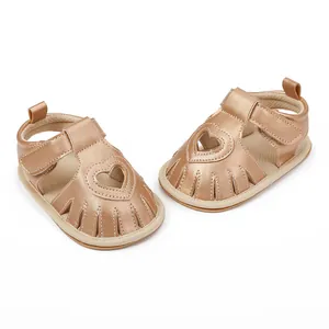 Detailed view of champagne gold baby sandals with heart cutout and velcro strap