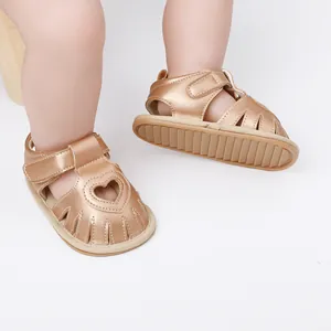 Macro detail of baby rose gold sandals featuring a cute heart cutout for infant girls