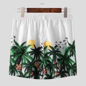 Back view of men's tropical print beach shorts featuring palm trees and sunset patterns