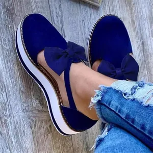 Gros plan sur des sandales à plateforme bleues avec un nœud élégant pour les femmes.