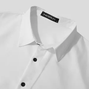 Close-up view of white men's shirt collar featuring black buttons and brand label