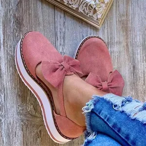 Vue détaillée des chaussures à plateforme en daim rose avec nœud et coutures élégantes