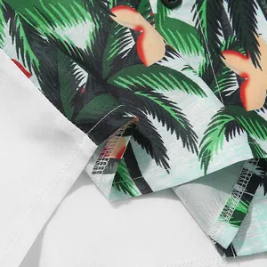 Close-up of tropical palm tree print and stitching on Hawaiian beach shirt.