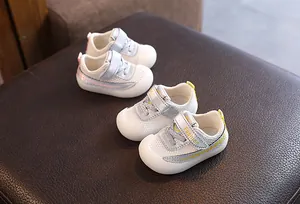 Gros plan de chaussures de marche pour bébé en maille respirante avec embouts en gomme.