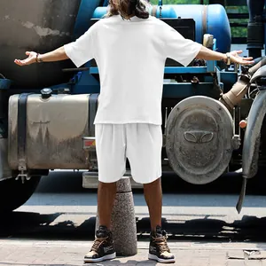 Modèle masculin en ensemble de sport d'été blanc oversize sur fond industriel