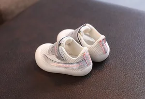Gros plan de chaussures de marche pour bébé en maille blanche respirante avec velcro