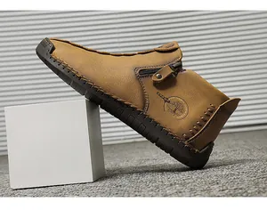 Close-up of handmade brown leather men's high-top shoe with side zipper and tree logo.