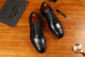 Vista superior de zapatos Oxford de cuero negro en un escritorio de madera clásica