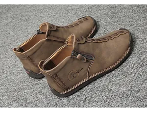 Detailed side view of brown leather high-top shoes featuring a zipper and embossed logo.