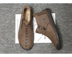 Detail view of brown men's high-top leather shoes with handmade stitching and side zipper