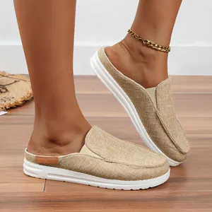 Detailansicht der beigen Leinen-Mules für Damen auf einem Holzboden im Sommer