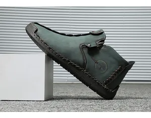 Side detail of hand-stitched men's high-top leather shoes with zipper in teal finish