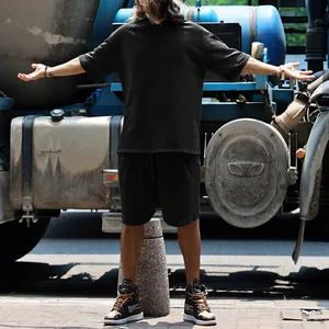 Λεπτομέρεια μαύρου oversized t-shirt και σορτς σετ για άνδρες σε στυλ street style.