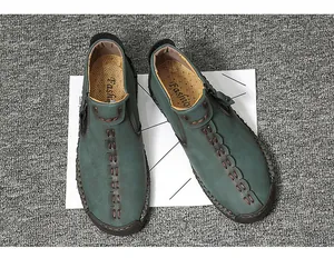 Detailed overhead view of dark green men's casual leather shoes with handmade stitching