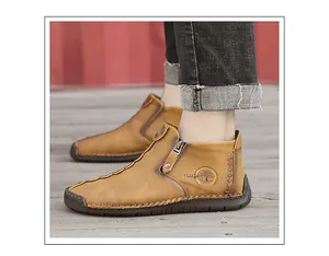 Close-up of men's brown leather high-top shoes with side zipper and handmade stitching details.
