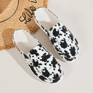 Trendige flache Damen-Mules mit hochwertigem Canvas-Obermaterial im Kuhmuster-Design