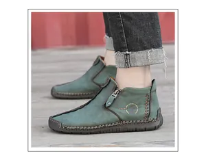 Detailed view of men's vintage green high-top leather shoes with zipper and stitching