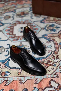 Primer plano de zapatos Oxford de cuero negro de alta calidad en una alfombra