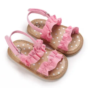 Detail van roze babysandalen met ruches en binnenzolen met wit stippenpatroon