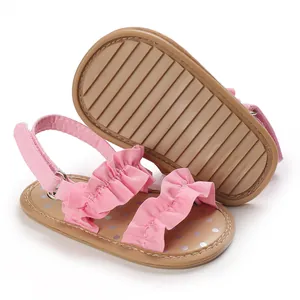 Gedetailleerde macro weergave van roze baby sandalen met antislip rubberen zool