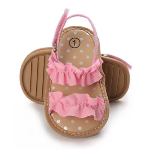 Gedetailleerd overzicht van roze baby sandalen met ruches, stippen en antislip rubberen zool