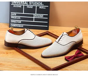 Gros plan de chaussures de ville pour hommes en cuir blanc perforé et respirant