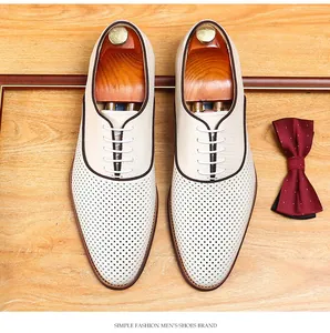 Vue de dessus de chaussures en cuir perforées pour hommes sur fond bois