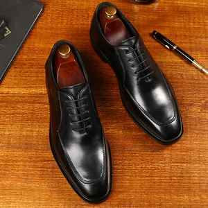 Zapatos Oxford clásicos de cuero negro para hombre, estilo de negocios sobre madera.