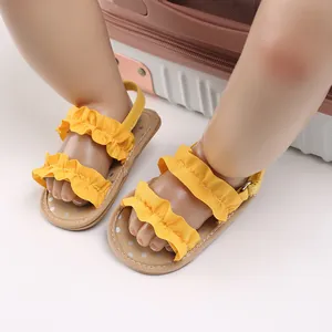 Close-up van gele baby sandalen met ruches en antislip rubberen zolen voor pasgeboren meisjes