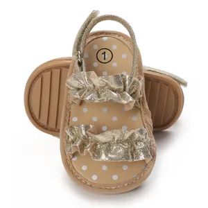 Detailweergave van gouden babysandalen met ruches en witte polkadot binnenzolen