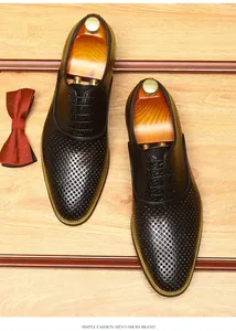 Détail du motif ajouré respirant sur des chaussures de ville élégantes en cuir noir