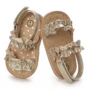 Detailopname van gouden baby sandalen met ruches en vrolijke stippen binnenzool