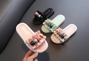 Close-up of girls' ruffled summer slides featuring colorful bead accents and thick sole