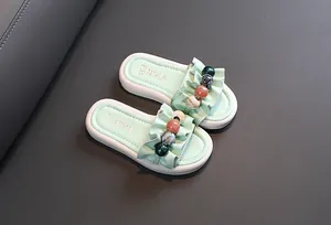 Detailed view of mint green girl's summer slippers with ruffles and colored beads