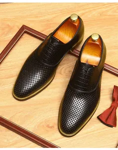 Détail des chaussures de ville en cuir noir ajouré et respirant pour hommes.