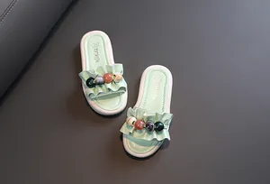 Close-up detail of mint green girls' sandals featuring stylish ruffles and colorful beads