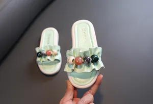 Detailed view of mint green girls' sandals with ruffled strap and decorative beads