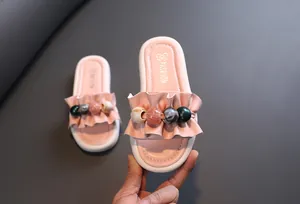 Detail of pink girls' platform sandals with ruffle strap and colorful beads