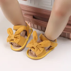 Detailed view of yellow corduroy baby girl sandals featuring a large decorative bunny bow
