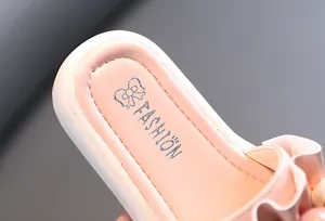 Detail view of pink girl slipper insole featuring fashion print and ruffled edges.