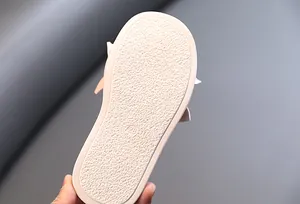 Detail of the anti-slip textured rubber sole on girl's pearl slippers, size 28 mark