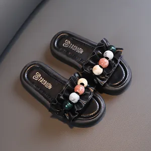 Stylish black girls' slippers with ruffled band and colorful pearl beads detail.