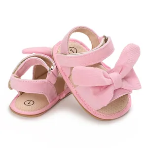 Detailed view of pink infant girl sandals featuring a large bow and corduroy finish