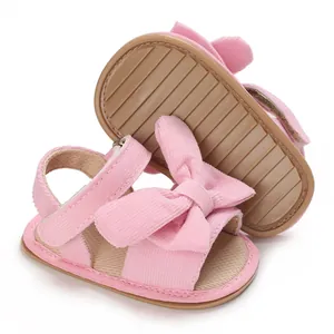 Close-up of pink corduroy baby girl sandals with large bow and anti-slip sole for summer