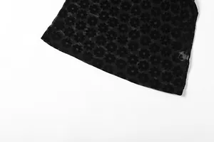 Makrodetail aus schwarzem, durchsichtigem Netzstoff mit elegantem Blumenmuster