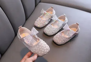 Nahaufnahme glitzernder rosa Prinzessinnenschuhe für Mädchen mit Strass und Perlen.